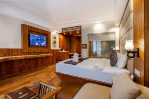Renovated hotel room with bed, television and wood floors showing hotel PIP depreciation items