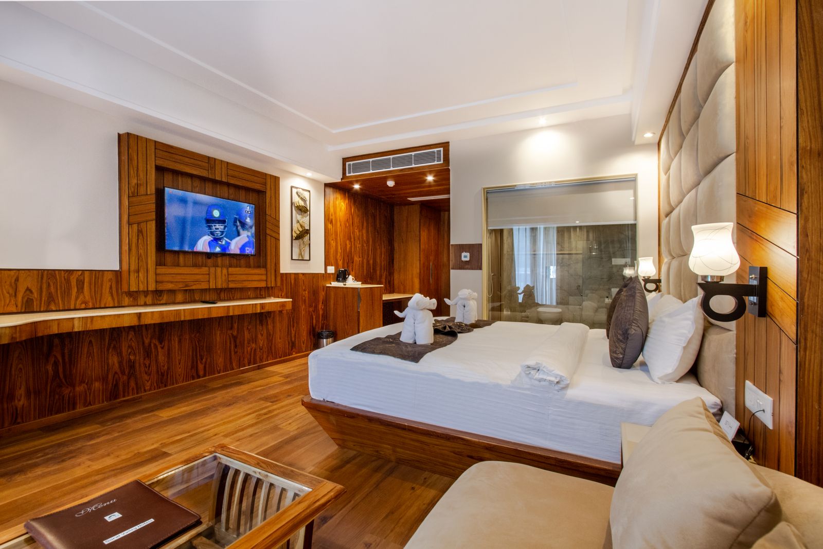 Renovated hotel room with bed, television and wood floors showing hotel PIP depreciation items